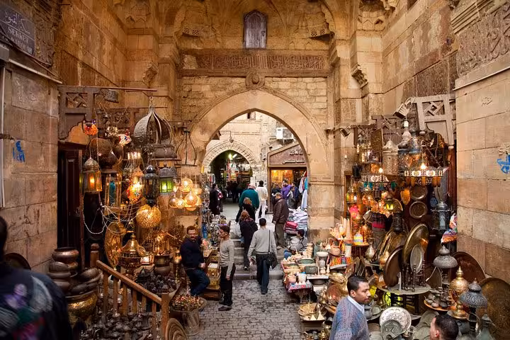 Khan el Khalili bazaar alley with hanging lanterns and brassware, featured on Coptic Cairo day tour