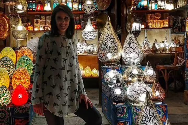 Traveler browsing colorful mosaic lanterns in Khan el-Khalili bazaar on a Medieval Cairo shopping tour
