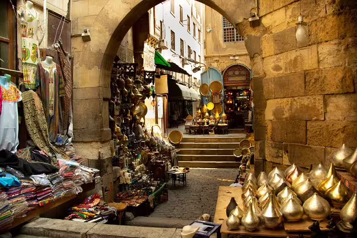 Khan El Khalili bazaar alley with brass lanterns and textiles on Port Said to Cairo tour