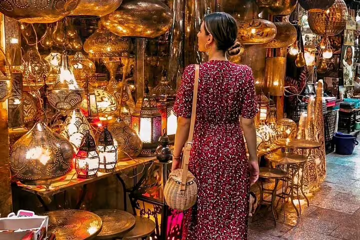 Visitor in Khan el-Khalili exploring brass lamps and lanterns during a Medieval Cairo bazaars shopping tour