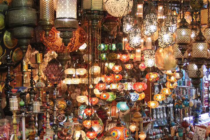 Crowded Khan El Khalili market with hanging mosaic lamps, a popular shopping stop on Cairo day tour from Alexandria