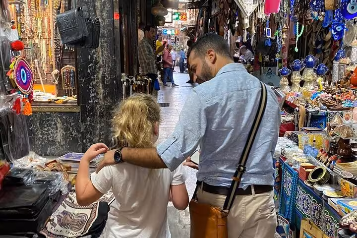 Guide and guest walking through Khan el-Khalili market alley, exploring Cairo hidden gems and local crafts