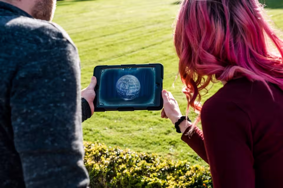 Kids engaged in a Magic Portal outdoor escape game in Malaga, using a tablet to solve puzzles on a sunny day.