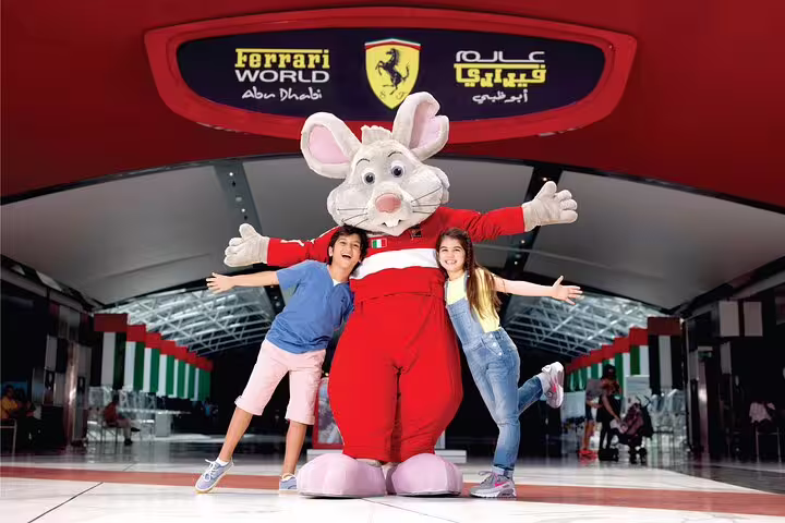 Joyful moment with kids posing with a mascot at Ferrari World Abu Dhabi, highlighting family-friendly attractions.