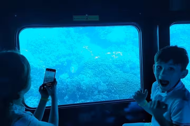 Kids viewing Red Sea coral through semi submarine window on Sharm El-Sheikh underwater tour with transfer