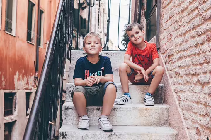 Kids on narrow Venice alley staircase, candid family portraits on a private personal travel photographer tour