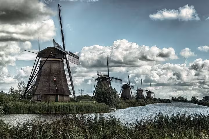 Kinderdijk windmills lining a canal under dramatic clouds on a private day tour from Amsterdam