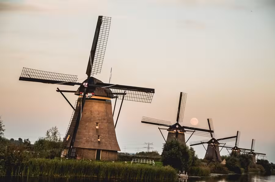 Kinderdijk windmills at sunset beside canal, highlight stop on private tour from The Hague, Leiden or Noordwijk