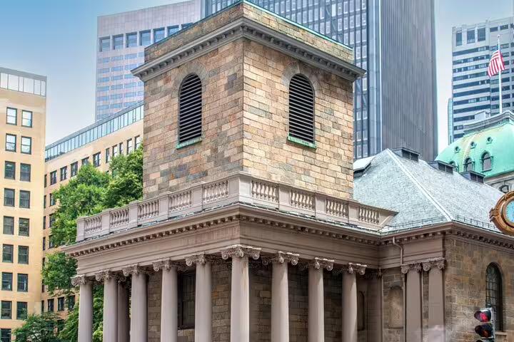 Historic King's Chapel with Greek columns on Boston Freedom Trail surrounded by modern skyscrapers