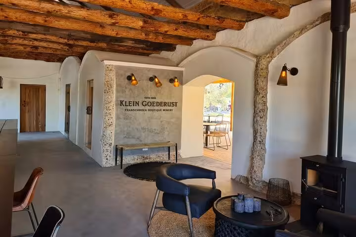 Charming interior of Klein Goederust Franschhoek winery, showcasing rustic decor and inviting seating area.
