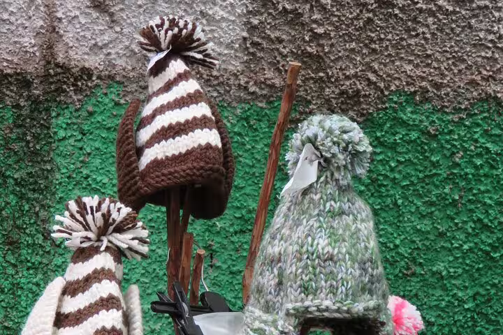 Colorful knit hats on display at a local farmers market in Funchal, showcasing artisanal crafts during a 4WD tour experience.