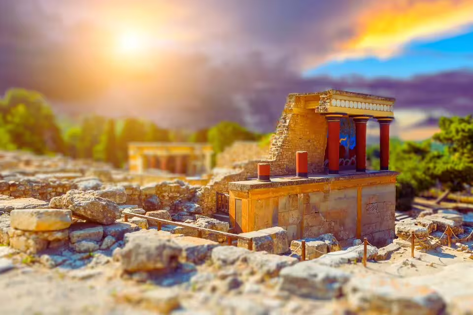 Breathtaking view of the ancient Knossos Palace on Crete, captured at sunset with vibrant colors in the sky.