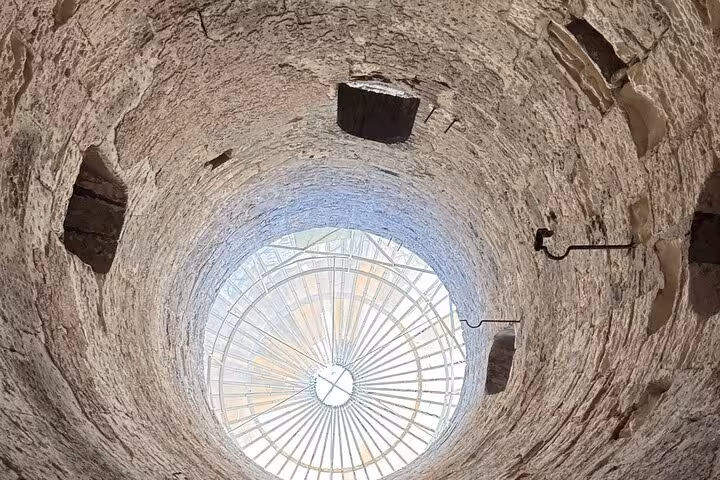 View up the spiral shaft and skylight at Kom El Shoqafa Catacombs on Alexandria private VIP day tour