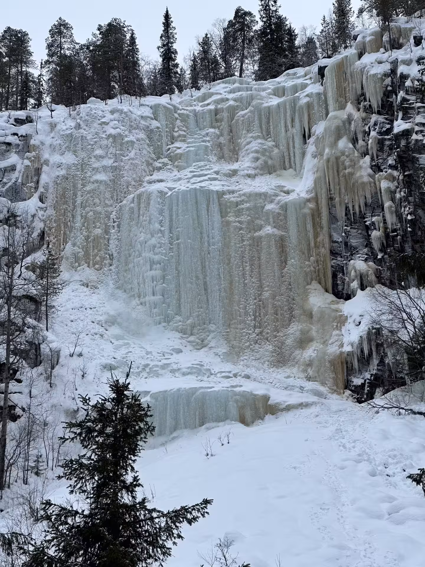 Explore the majestic Korouoma frozen waterfalls surrounded by snow-covered cliffs and serene winter landscapes.