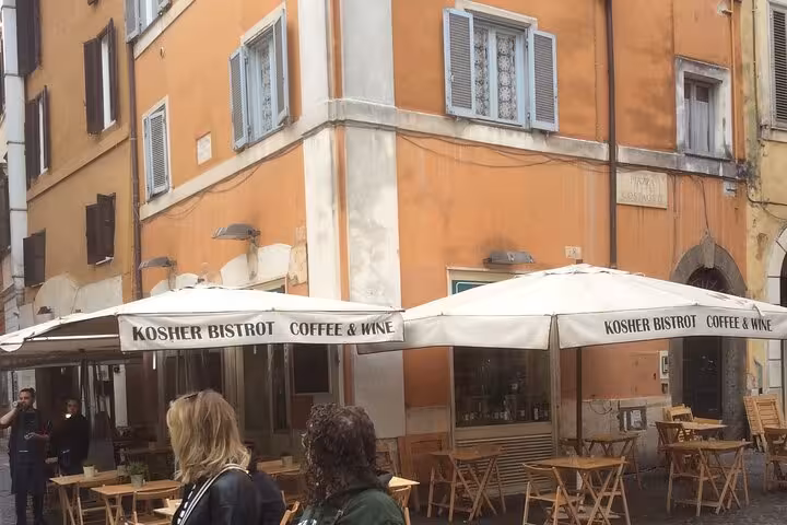 Charming Kosher Bistro in Rome's Jewish Ghetto offering coffee and wine with rustic outdoor seating.