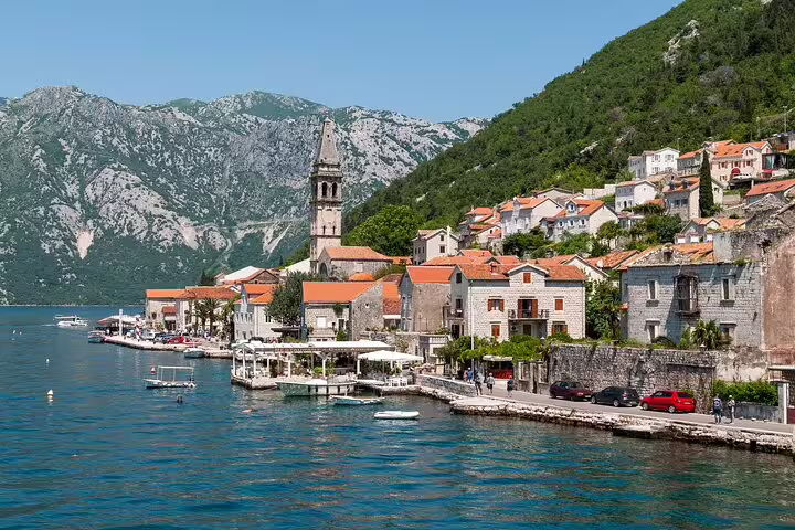 Kotor Bay waterfront village and mountains on route, private car transfer tour from Dubrovnik to Budva