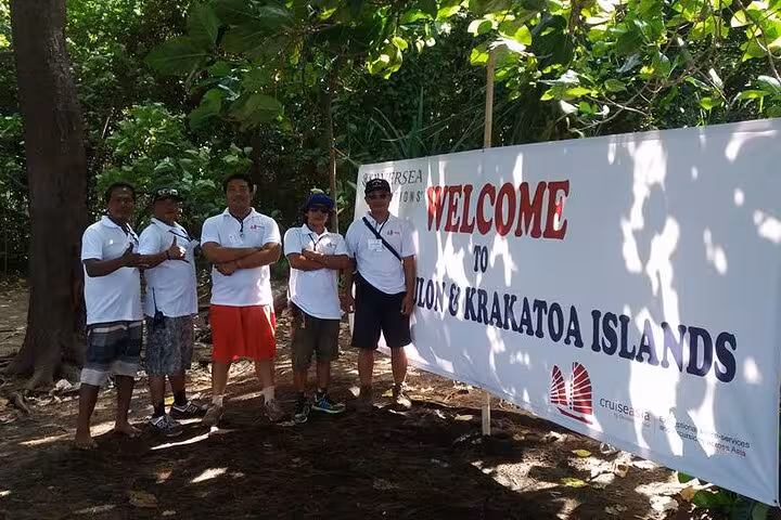Tour staff by Welcome to Krakatoa Islands sign, meeting point for Krakatau (Krakatoa) day trip adventure