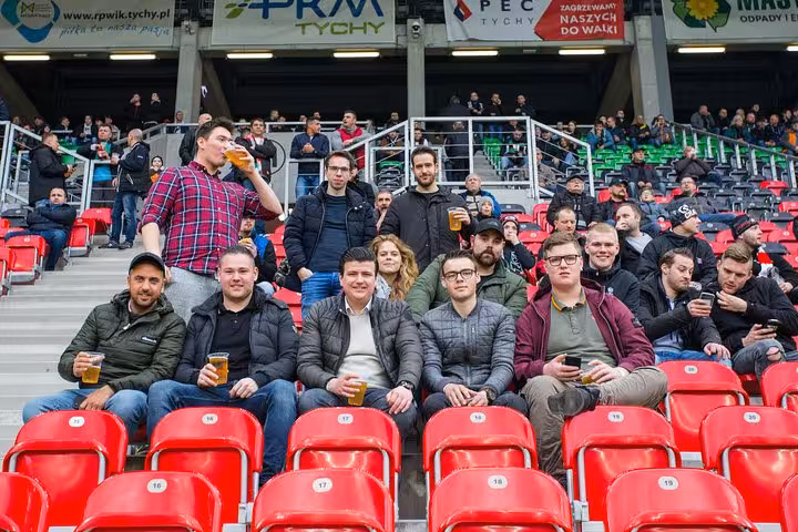 Group of fans with beers in stadium seats, Krakow football match tour with a local and lively atmosphere