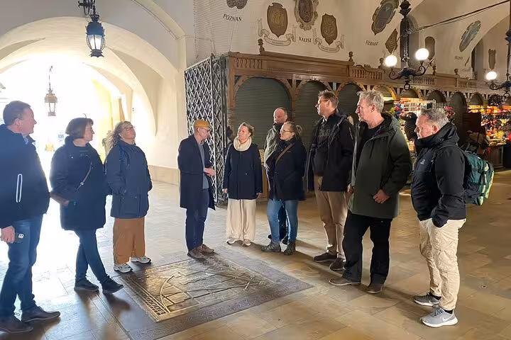 Group tour exploring Krakow's Jewish Quarter inside a historic building, led by an engaging guide.
