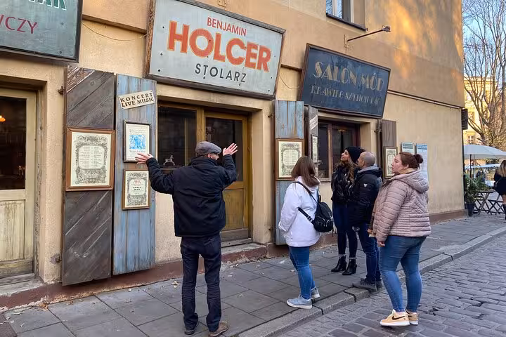 Tourists exploring historic Jewish shops on a guided walking tour in Krakow's renowned Jewish Quarter.