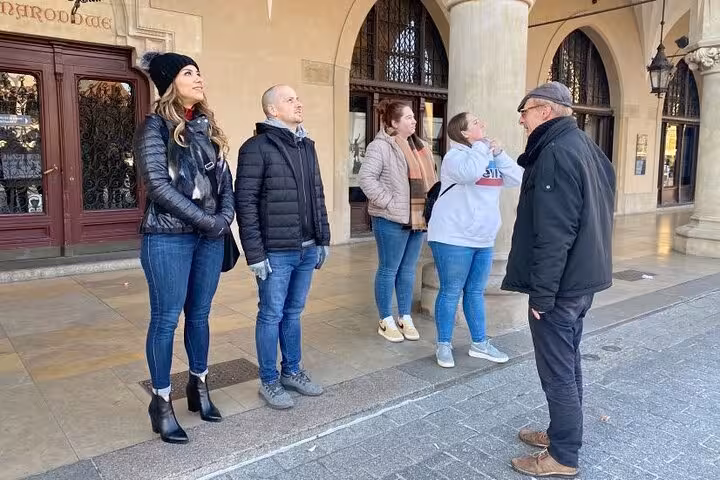 Tour group listening to a guide in Krakow's historic Old City during a magical 120-minute walking tour.