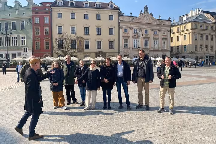 Visitors enjoying a guided tour in Krakow's picturesque Old Town square, exploring historic architecture.