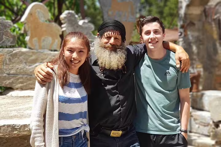 Visitors with local artisan in Kritza, experiencing authentic Cretan culture and hospitality.