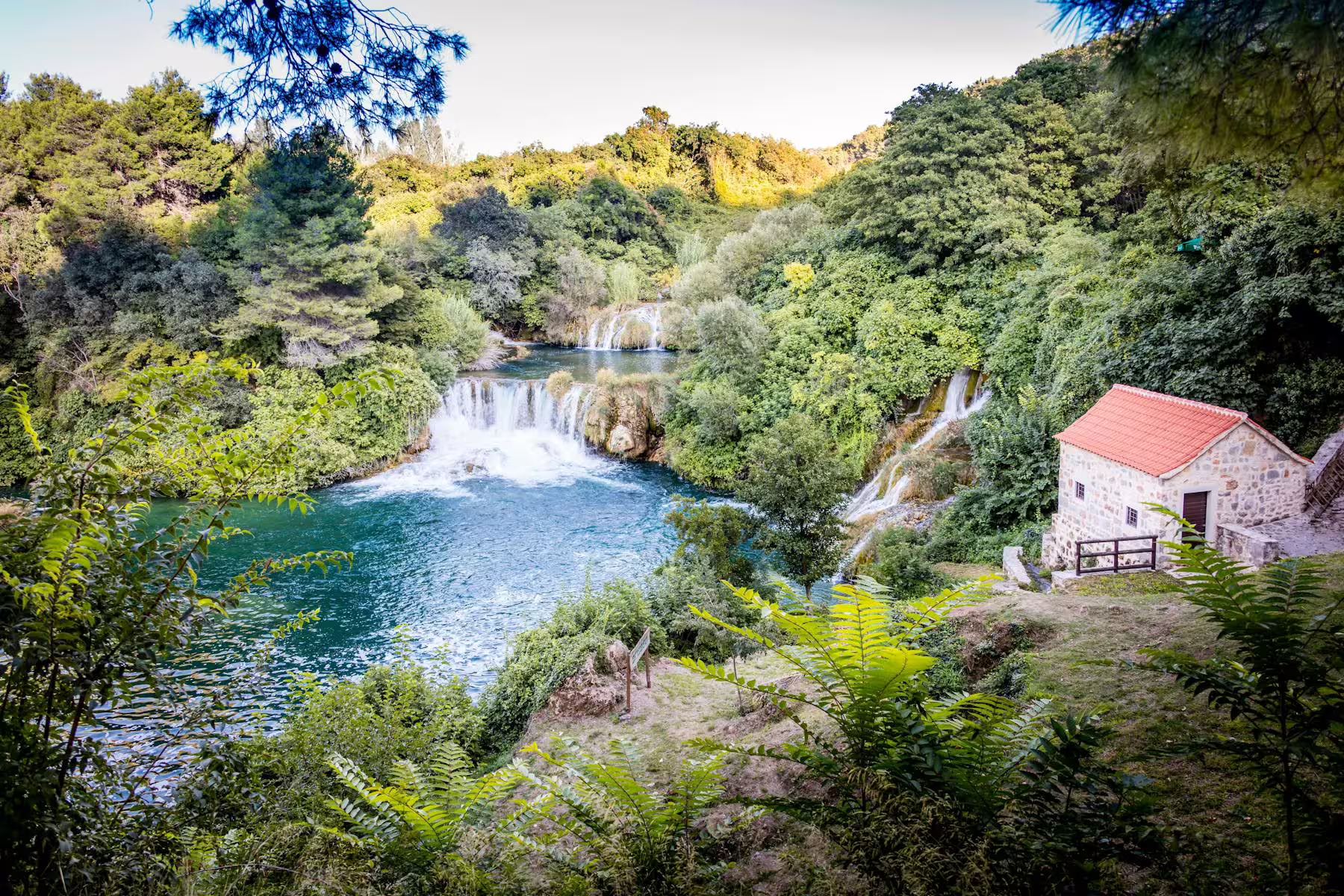 Krka National Park waterfalls and turquoise pool near a stone mill, scenic day trip from Zadar to Sibenik