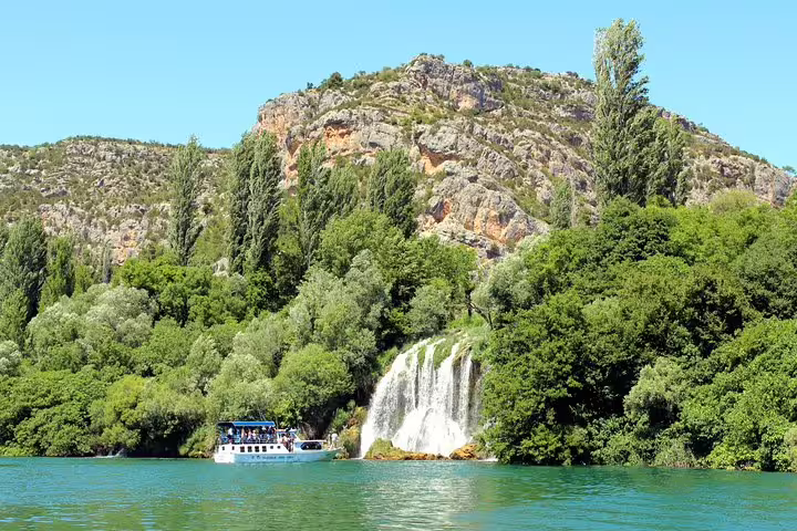 Boat cruise on Krka River by waterfall and cliffs, scenic Krka National Park and Waterfalls Tour Croatia