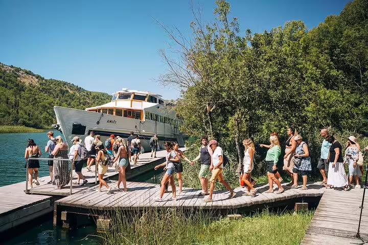 Boat boarding at Skradin pier for a private Krka Waterfalls tour, scenic river cruise to the national park