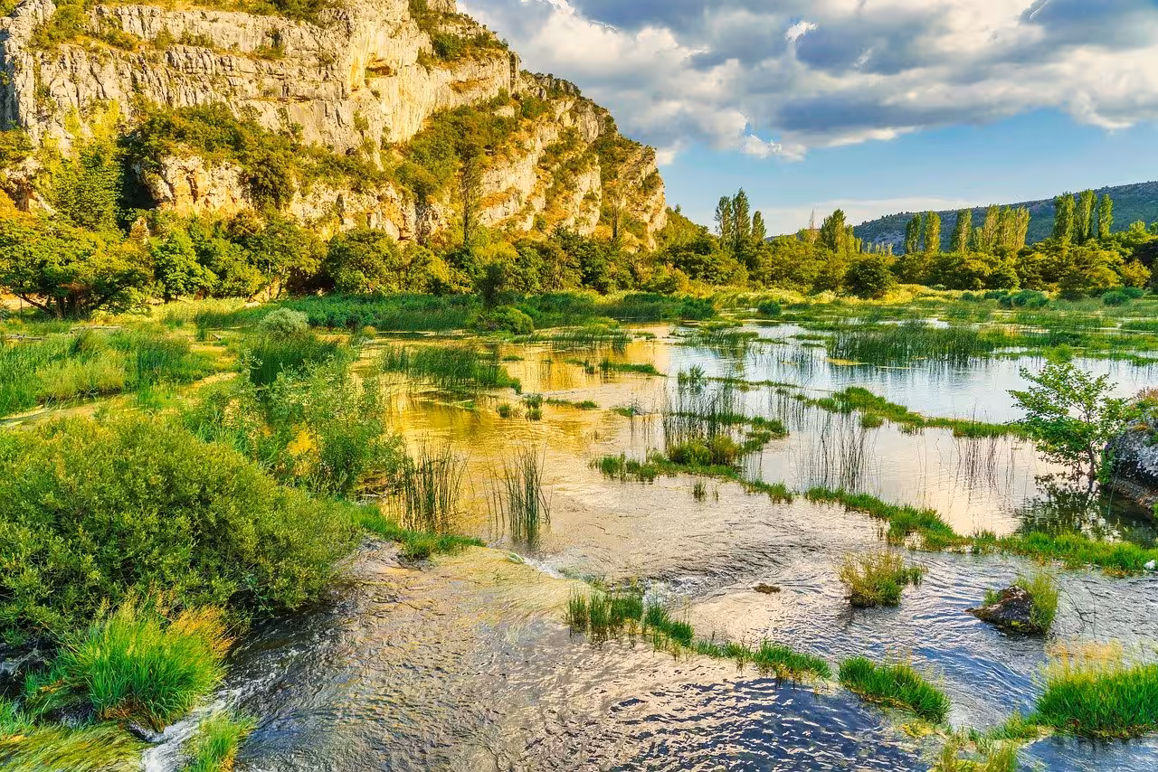 Scenic river wetlands and limestone cliffs on Krka National Park lake cruise route to Skradin Old Town tour