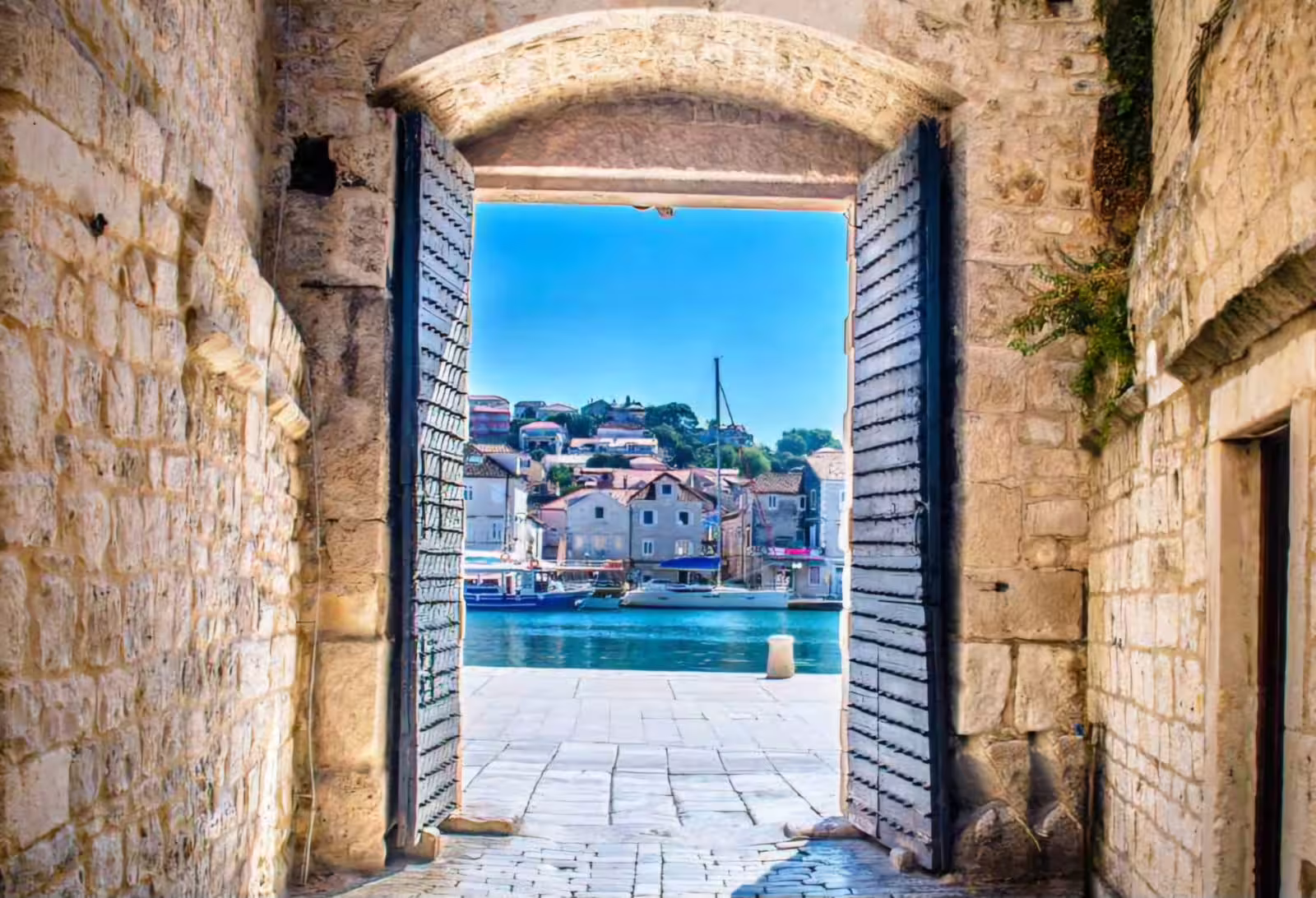 Stone gate opening to Šibenik waterfront and Adriatic harbor, scenic view on a private Krka Waterfalls tour