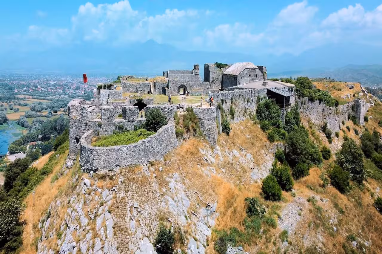 Aerial view of the historic Kruje Castle ruins surrounded by lush greenery in Albania.