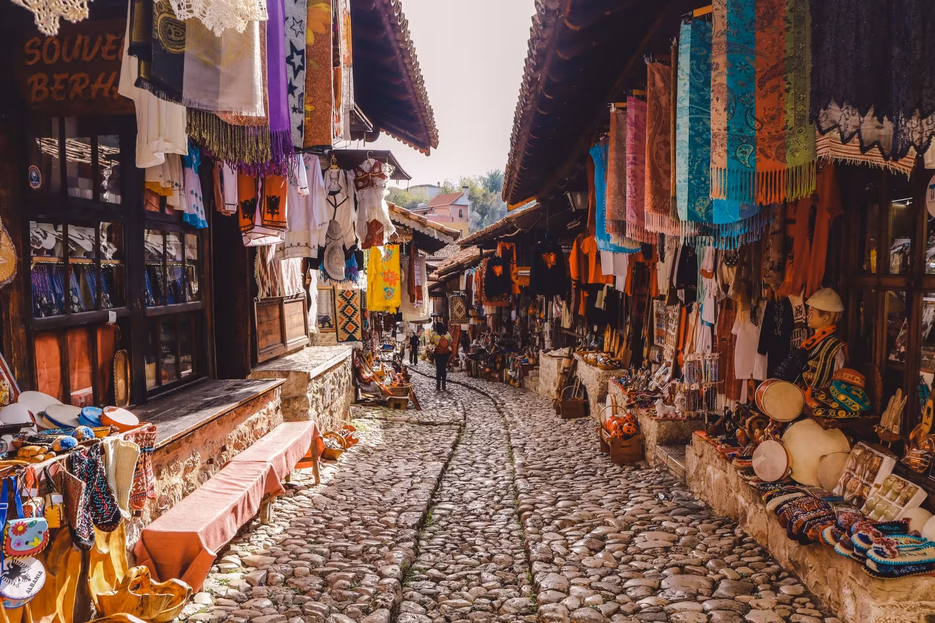 Colorful market street in Kruje with traditional crafts, perfect for exploring on the Day Trip to Shkoder and Kruje.