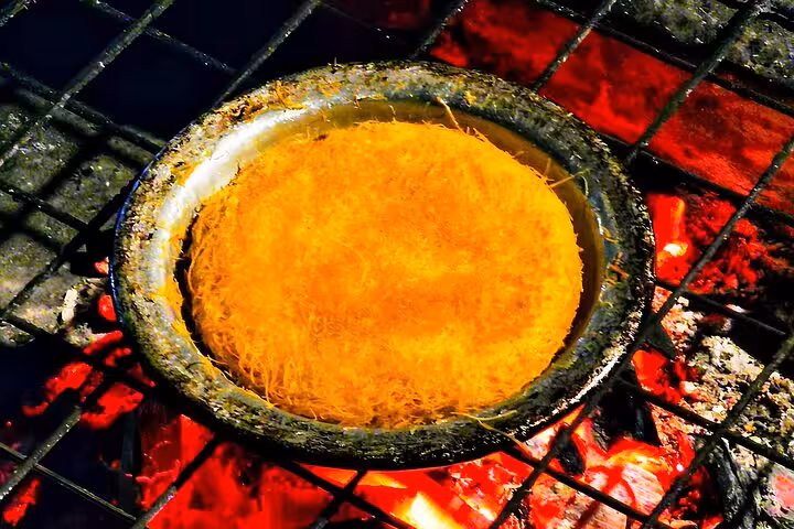Traditional kunafa dessert baking over coals at VIP Arabian Night Bedouin dinner show in Giza with photographer