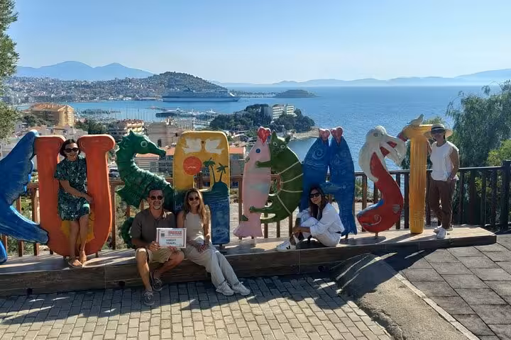 Kusadasi harbor viewpoint on Ephesus shore excursion, group photo at colorful Kusadasi sign by the sea