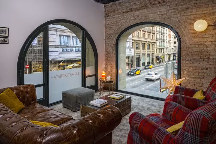 Cozy lounge area with street view in a designer loft, part of the La Boqueria Market tour and cooking class.