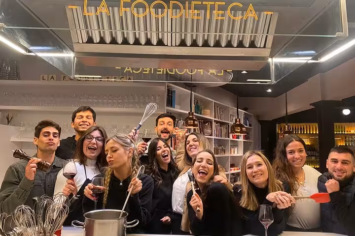 Group enjoying a cooking class at La Foodieteca, part of the La Boqueria Market Tour & Premium Cooking Class experience.