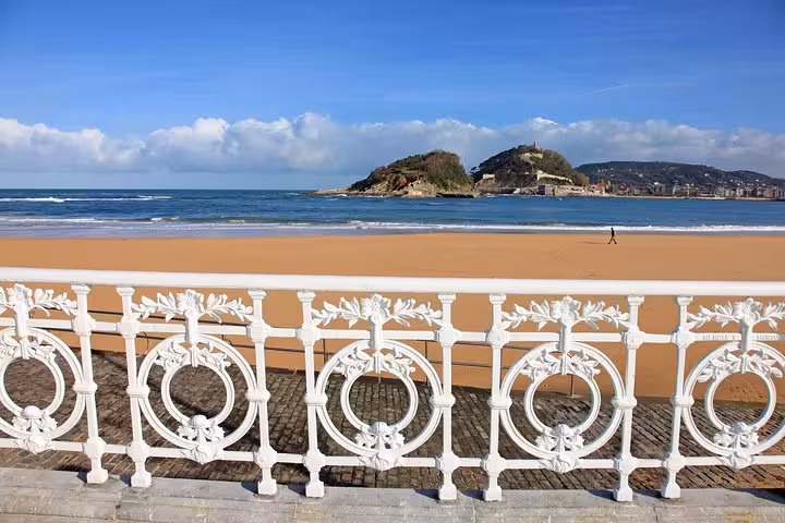 Picturesque view of La Concha Beach from ornate railing, showcasing San Sebastián's coastal beauty in Spain.