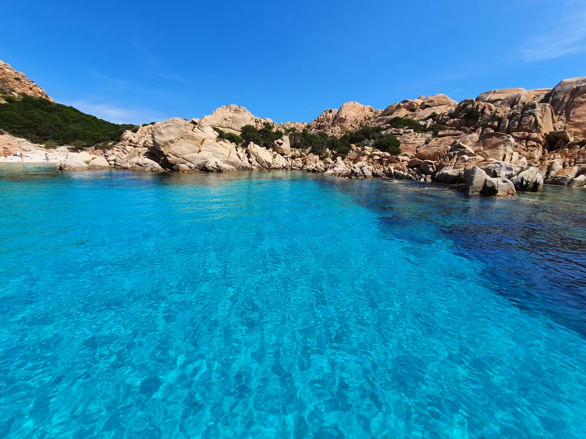 Crystal-clear turquoise waters with rocky coastline in La Maddalena Archipelago, perfect for a scenic RIB tour.