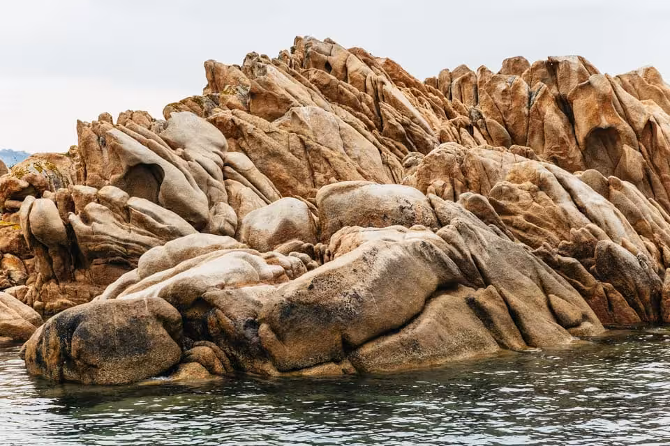 Close-up of rugged, sculpted rock formations rising from the water in the La Maddalena Archipelago.