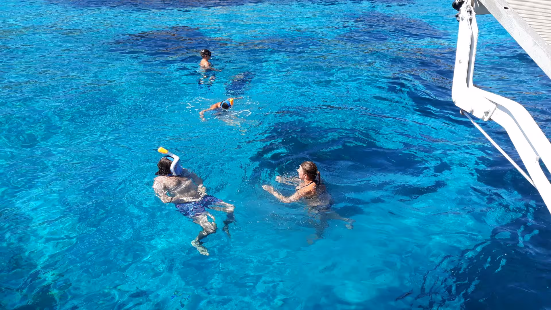 Tour participants snorkeling in the clear blue waters off La Maddalena during a scenic boat excursion.