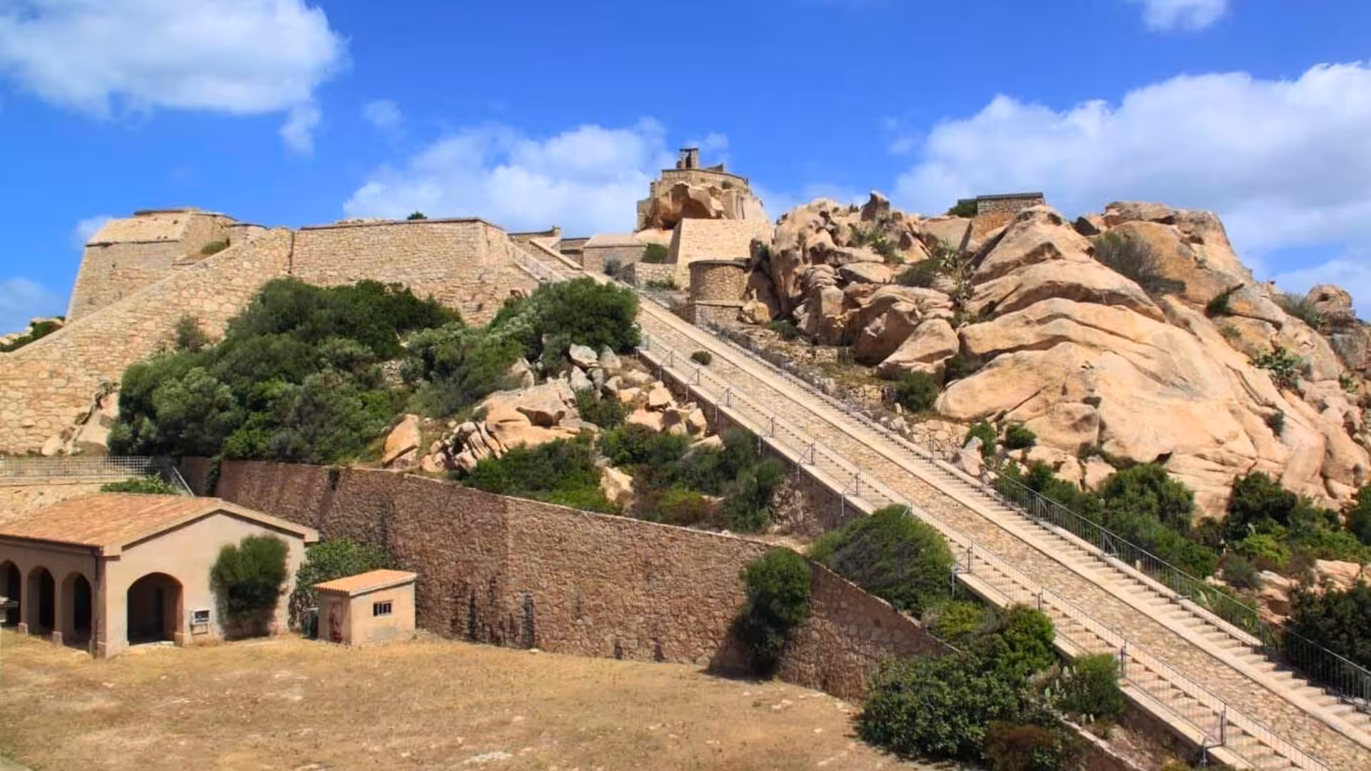 Historic fortress with stone steps and rugged landscape, showcasing La Maddalena's archaeological allure.
