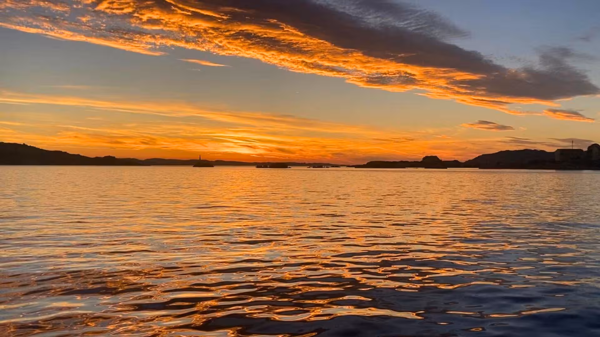 Breathtaking sunset over the calm waters of La Maddalena Archipelago, highlighting vibrant sky colors for a private tour.