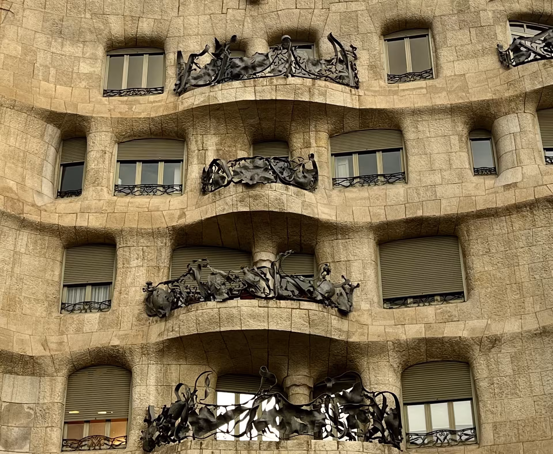 La Pedrera Casa Milà façade with wavy stone balconies and wrought-iron railings on Barcelona night tour