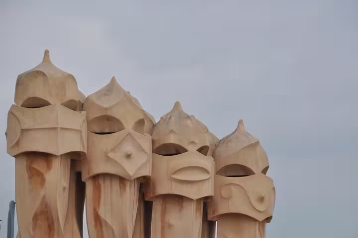 Artistic chimneys on La Pedrera's rooftop with Gaudí's signature design during a private tour in Barcelona.