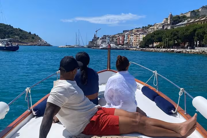 Passengers relax on a boat with a picturesque view of Lerici's coastline during the La Spezia 3-hour boat tour.