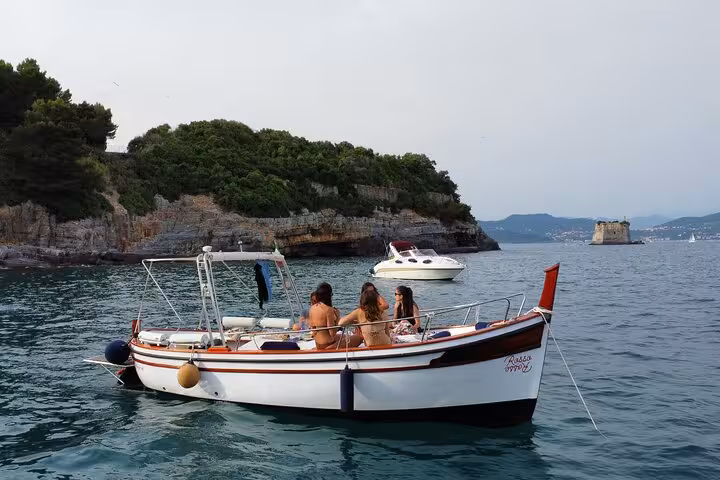 Tourists enjoy a scenic boat ride near La Spezia, exploring the stunning coastline and lush landscapes of Portovenere.