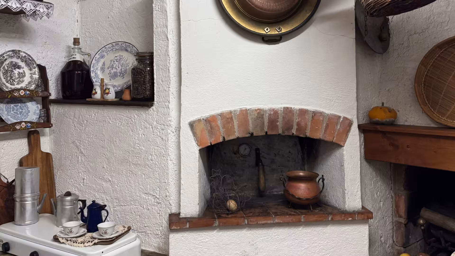 Cozy rustic kitchen with vintage stove, copper pot, and traditional Sardinian decor for Laconi chocolate and liqueur tour.