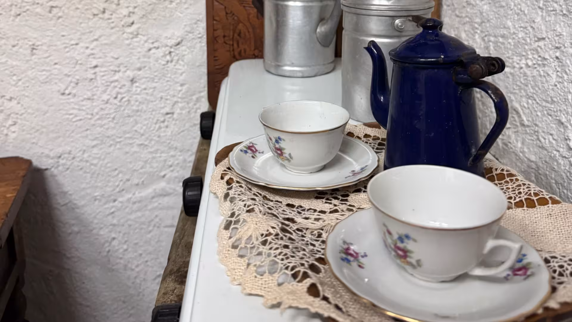 Vintage tea set with lace doilies, evoking traditional Sardinian charm for Laconi chocolate and liqueur experience.